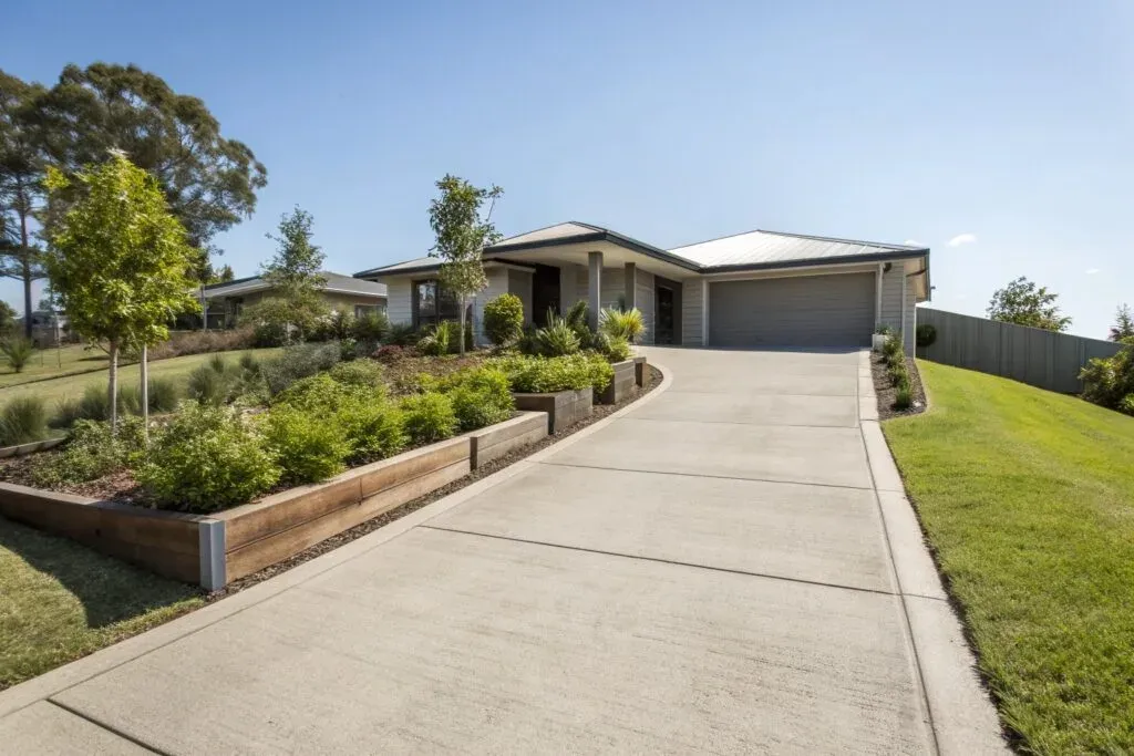 Smooth, well-maintained light-coloured concrete driveway leading to a Rangeville home